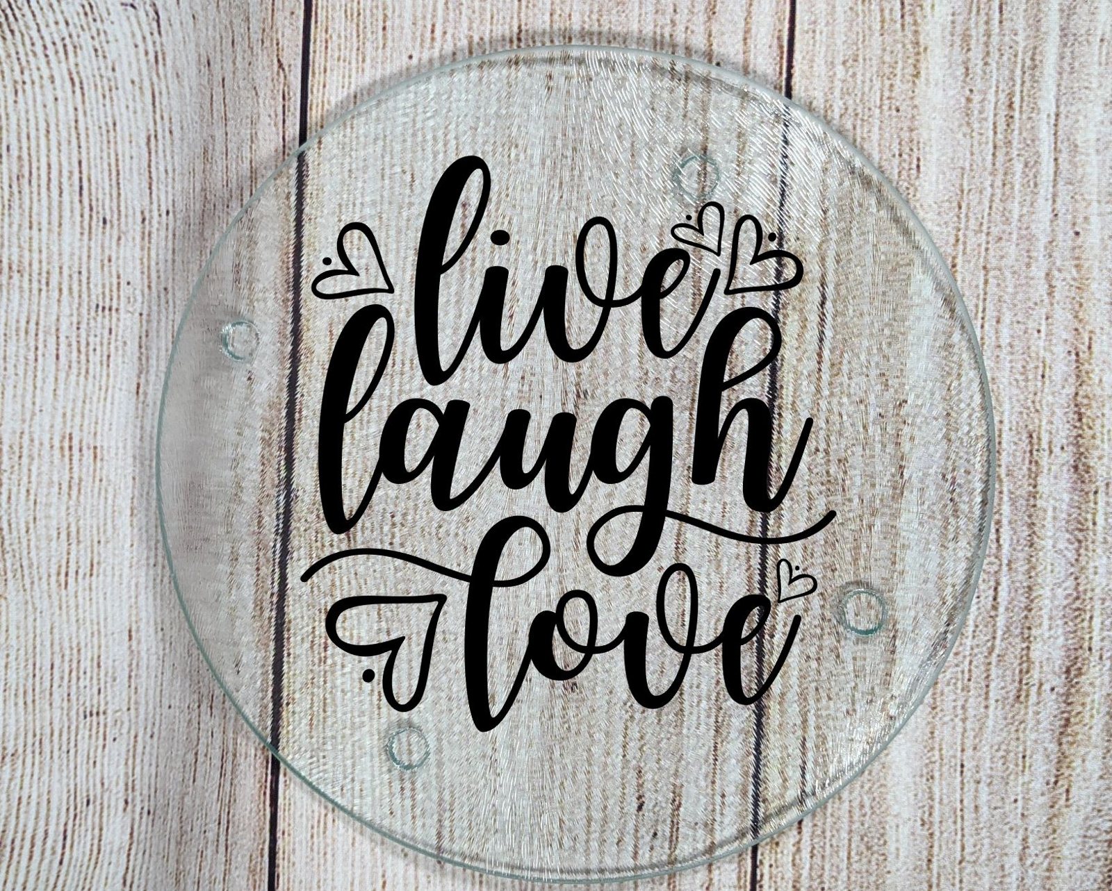 Round glass cutting board with a 'live laugh love' design